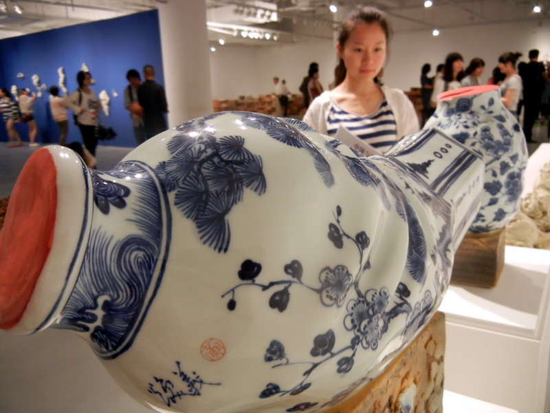 Une visiteuse admire une ?uvre d'art en céramique de Huang Huanyi intitulée ? Le Vase couché ?, au Musée d’Art du Lac Jinji de Suzhou, le 24 mai 2014. [Photo Wang Jiankang / asianewsphoto.com]