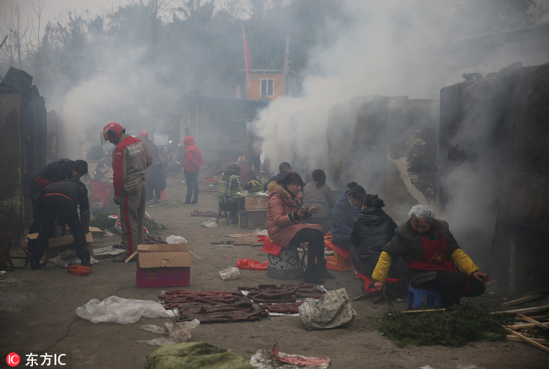 Les habitants du Sichuan portent des lunettes pour fumer de la viande pour le Nouvel An