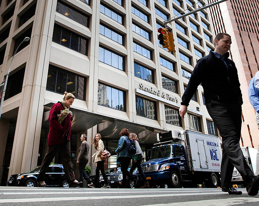 Des piétons traversent la rue dans laquelle se trouve l'immeuble de Standard & Poor's à New York. [Crédit photo : China Daily]