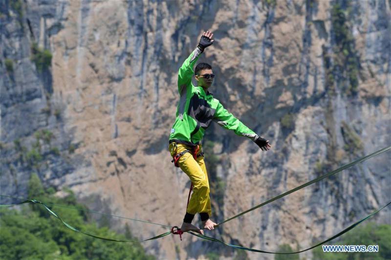 Homme fait de l'équilibre sur un fil dans une base de sports de plein air au Hubei