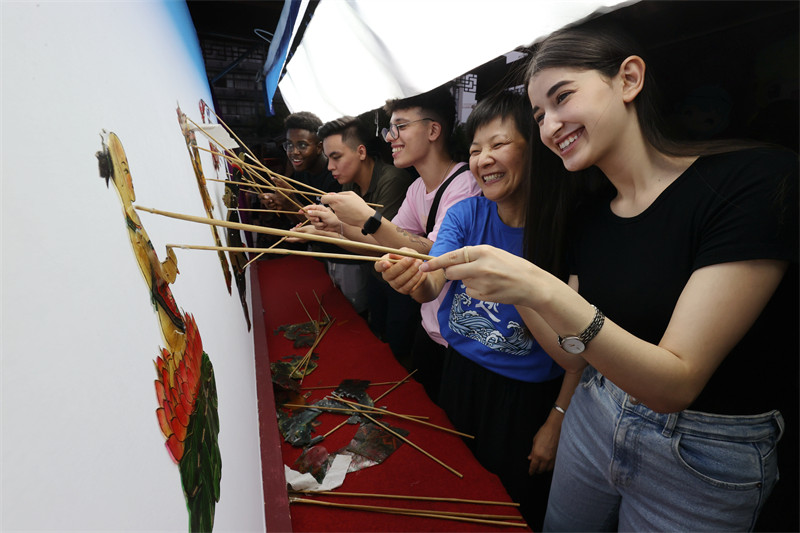 Zhejiang : des étudiants étrangers go?tent au charme du théatre d'ombres chinoises de Deqing