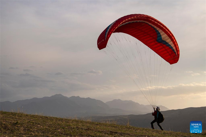 Un amateur de parapente cherche à découvrir davantage la beauté du Xinjiang depuis le ciel