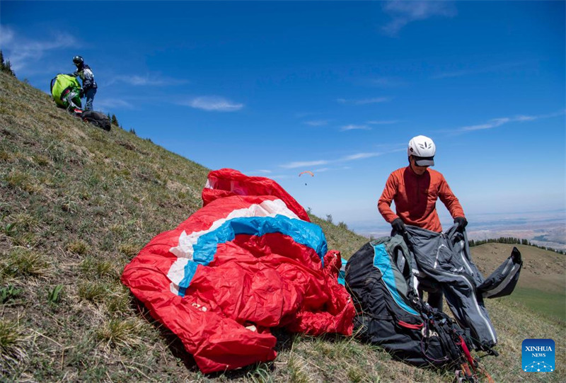 Un amateur de parapente cherche à découvrir davantage la beauté du Xinjiang depuis le ciel