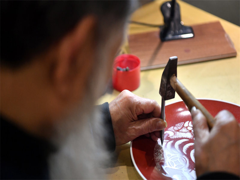 Jiangxi : un artisan grave sur porcelaine avec une technique délicate