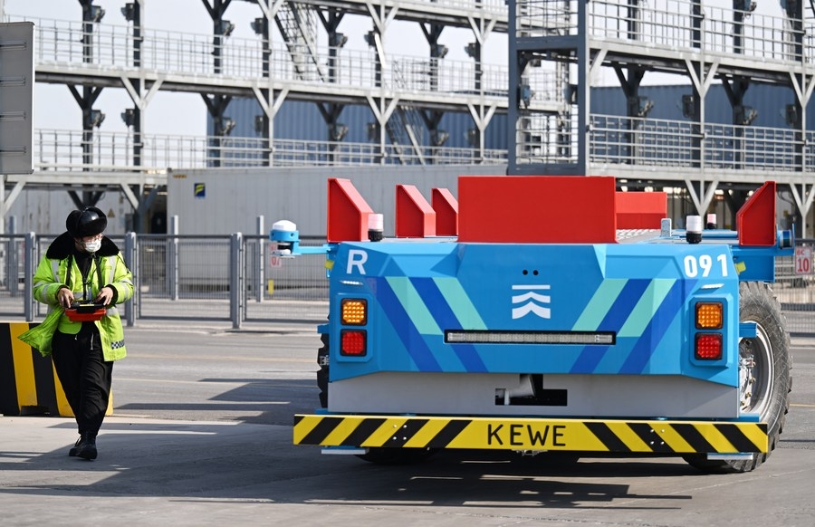 Un membre du personnel utilise un robot de livraison intelligent dans le terminal à conteneurs de l'Internet des objets du port de Tianjin, à Tianjin, dans le nord de la Chine, le 21 février 2023. (Photo : Li Ran)