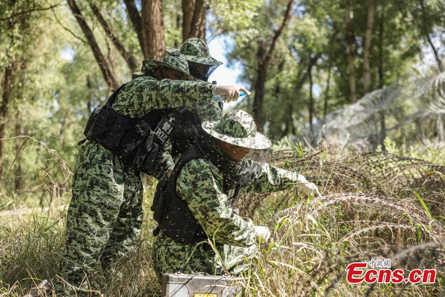 Des membres de la police armée populaire chinoise nettoient le limon dans une rue du district de Wanzhou, dans la municipalité de Chongqing (sud-ouest de la Chine), le 5 juillet 2023. (Meng Ranjun / China News Service)