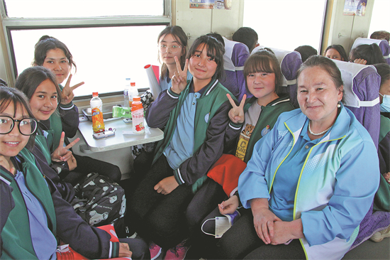 Un groupe d'étudiants et leur professeur partent en voyage d'étude en train le long de la voie ferrée Hotan-Ruoqiang dans la région autonome ou?ghoure du Xinjiang (nord-ouest de la Chine) en mai. (Photo / Xinhua)