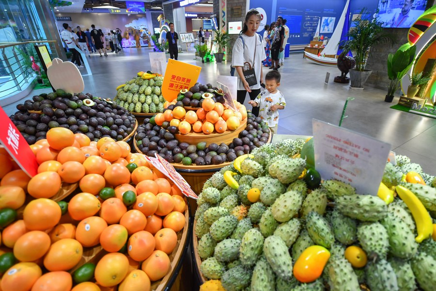 Une femme et son fils achètent des fruits africains au Parc de démonstration de l'innovation pour la promotion de la coopération économique et commerciale entre la Chine et l'Afrique, à Changsha, dans la province centrale du Hunan, le 1er juillet 2023.(Photo : Chen Zeguo)