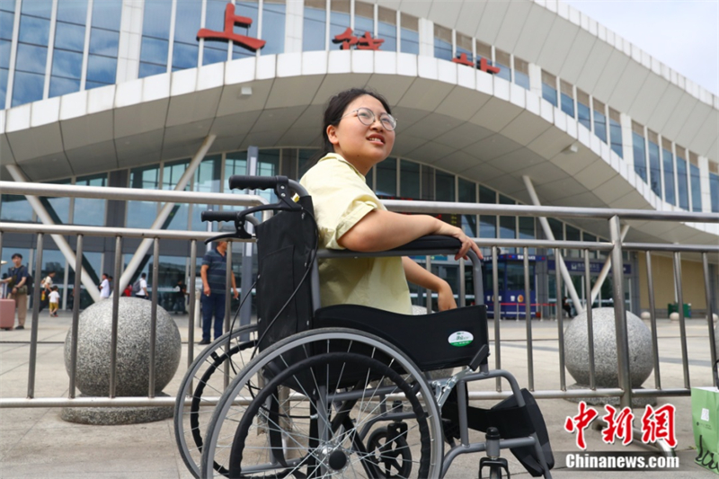 Jiang Zhangziyi est assise dans un fauteuil roulant devant la gare de Shangrao. (Photo / China News Service)