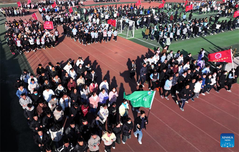 Photo aérienne prise le 25 décembre 2023 montrant des élèves faisant de l'exercice sur le terrain de sports d'un collège du comté de Minhe, dans la province du Qinghai (nord-ouest de la Chine). (Wang Bo / Xinhua)