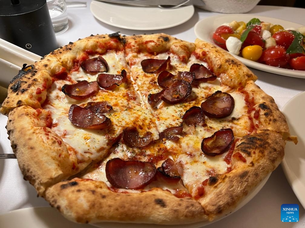 Photo prise le 16 novembre 2023 montrant une pizza garnies de saucisses produites dans la province du Guizhou (sud-ouest de la Chine), qui servent de garniture innovante, dans un restaurant de Chongqing (sud-ouest de la Chine). (Yang Shiyan / Xinhua)