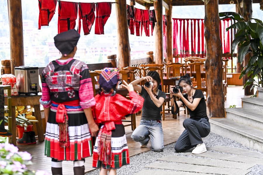 Des membres du personnel prennent des photos pour les touristes dans un séjour chez l'habitant du village de Dazhai, dans le comté de Longsheng de la région autonome Zhuang du Guangxi (sud de la Chine), le 11 juillet 2024. (Photo / Xinhua)