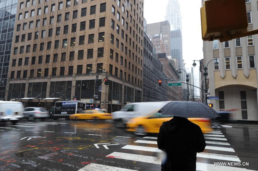 Un homme traverse la rue sous la neige, à New York, aux Etats-Unis, le 8 mars 2013. La ville de New York a été frappée vendredi par une tempête de neige. (Photo : Niu Xiaolei)