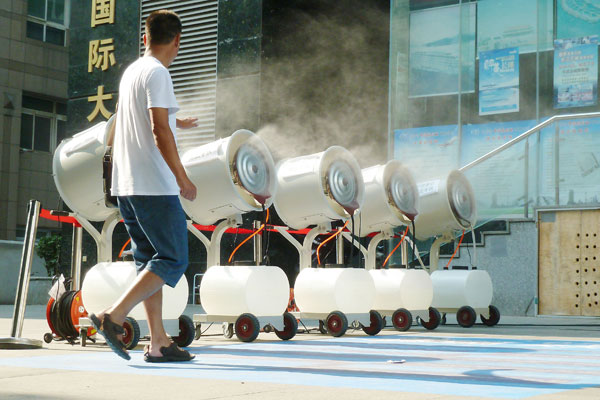 Cinq ventilateurs de refroidissement tournent à plein régime devant un magasin de Nanjing pour rafra?chir les passants, la province du Jiangsu dans l'est de la Chine, le 29 juillet 2013.