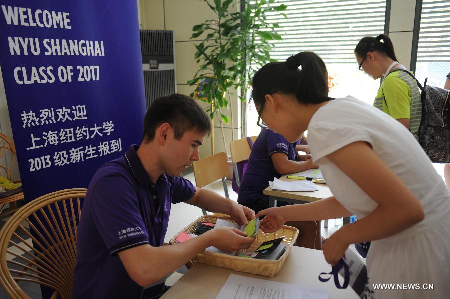 Le 11 ao?t 2013, une étudiante de l'Université New York-Shanghai prend sa carte de chambre auprès d'un employé. (Photo : Xinhua/Liu Xiaojing)