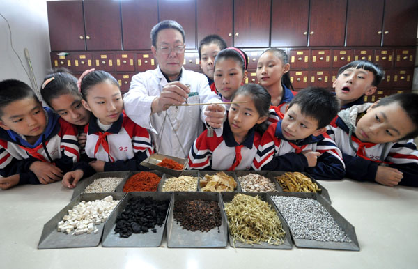 Des élèves de l'école primaire Zhuhelu de Handan suivent une démonstration de médecine traditionnelle chinoise (MTC) le 21 octobre 2013, à Handan, dans la province du Hebei.[Photo Hao Qunying/Asianewsphoto ]