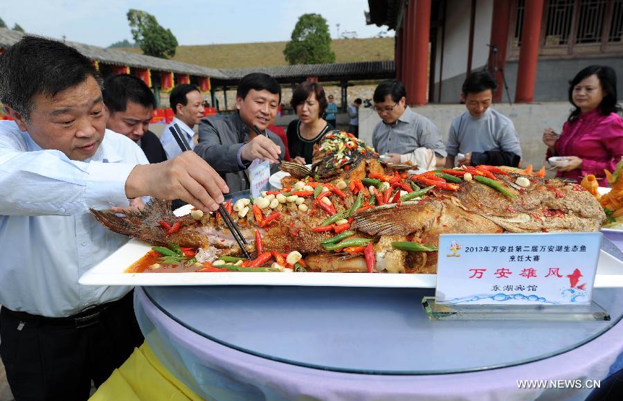 Le jury go?t plusieurs plats de poissons préparés par les candidats, lors d'un concours de cuisine organisé le 30 octobre dans le district de Wan'an, la province chinoise du Jiangxi. (Photo/Xinhua/Zhou Ke)