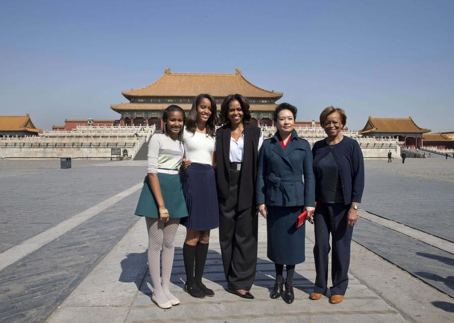 La première dame des états-Unis Michelle Obama (au centre), ses filles Sasha (à gauche) et Malia (2e à gauche) et sa mère Marian Robinson (à droite) posent avec Peng Liyuan, l'épouse du président chinois Xi Jinping, lors de leur visite de la Cité Interdite à Beijing, le 21 mars 2014.